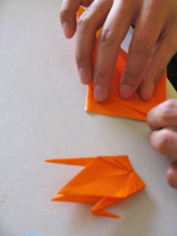 hands folding origami crane