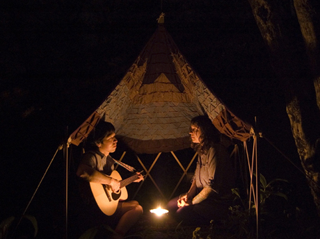 photo of two people in front of camp fire playing guitars