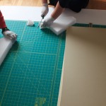 Photograph of student preparing an artwork for storage or travel