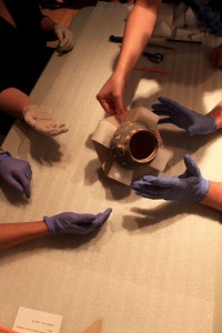 Photograph of students preparing an artwork for storage or travel