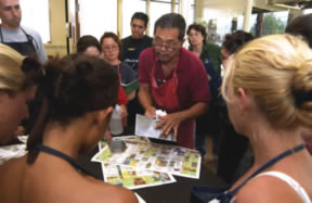 Wayne Miyamoto teaching art at UH Hilo, with students gathered around