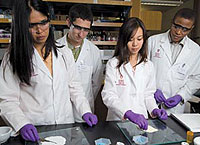 group of pharmacology students in white lab coats
