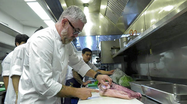 Chef Atala cutting meat