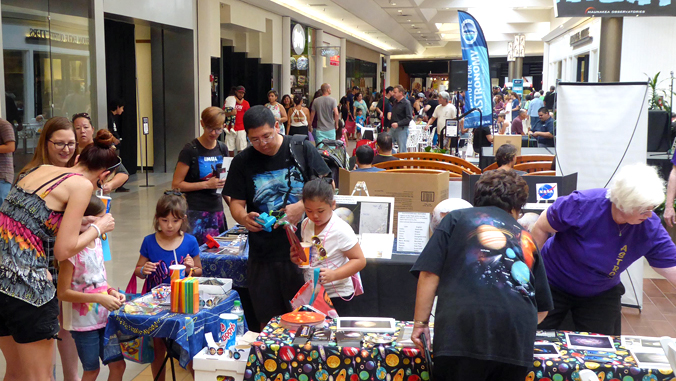 people participating at science displays in the mall