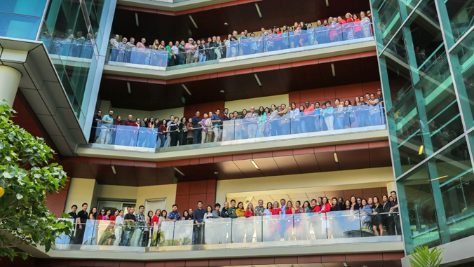 large group of people standing on multiple floors of UH Cancer Center walkways