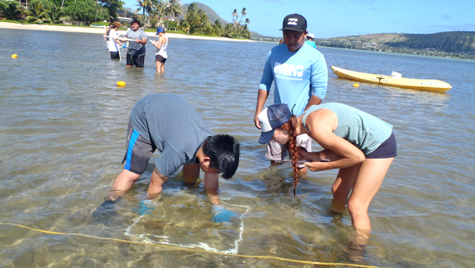 two students collecting algae samples in the ocean