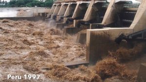 brown water pouring out of dam