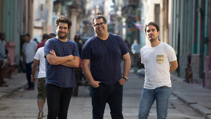 three men standing and smiling at the camera