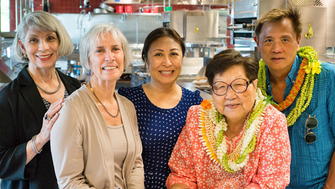 five people standing in the Culinary Institute of the Pacific kitchen
