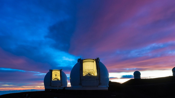 two telescopes on Maunakea against night time sky