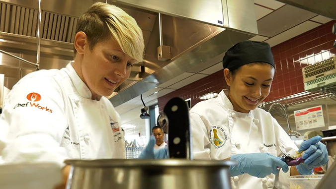 Two culinary students working in a kitchen