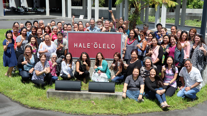 large group of people around Hale Oolelo sign
