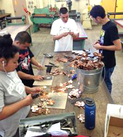student putting together copper roses