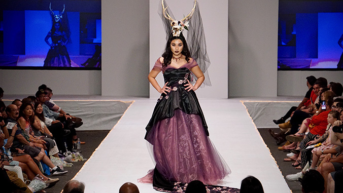 Model in a black and mauve dress with animal skull headdress