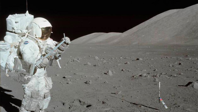 Astronaut walking on the moon taking lunar samples.