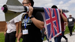 Project Imua students carrying their rocket with the Hawaii flag