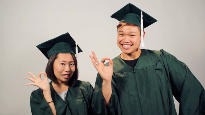 two uh manoa students in their graduation gowns