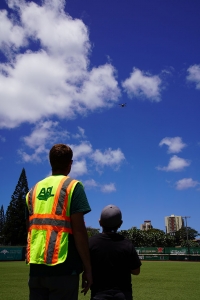 Man instructs boy operating drone