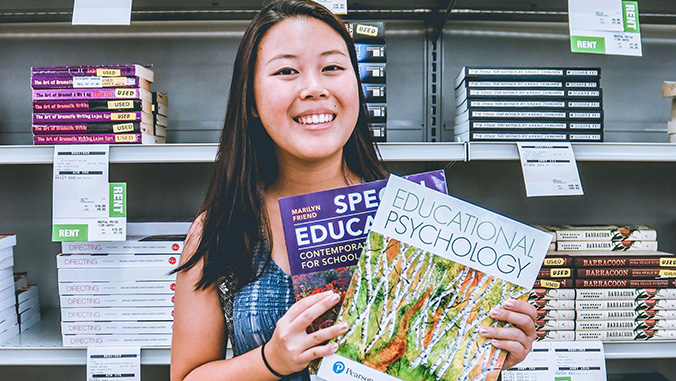 Student holding textbooks at the bookstore