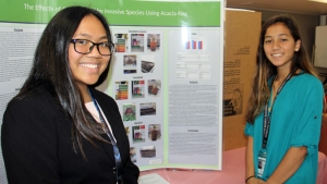 two people next to science fair exhibit