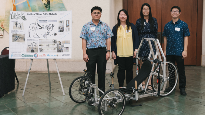 four engineering students standing in front of project