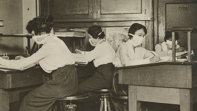 women at their desk wearing mask