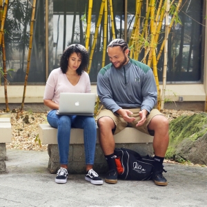 Two U H Manoa students sitting on a bench