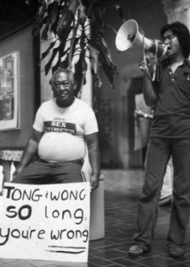 dean alegado speaking with a megaphone standing next to a man