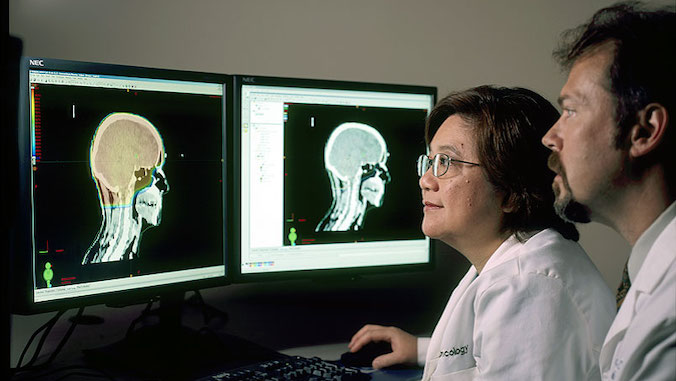 two researchers looking at brain scans