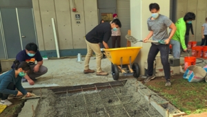 people help to create a concrete ramp