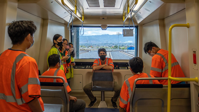 people sitting in a rail car with vests on
