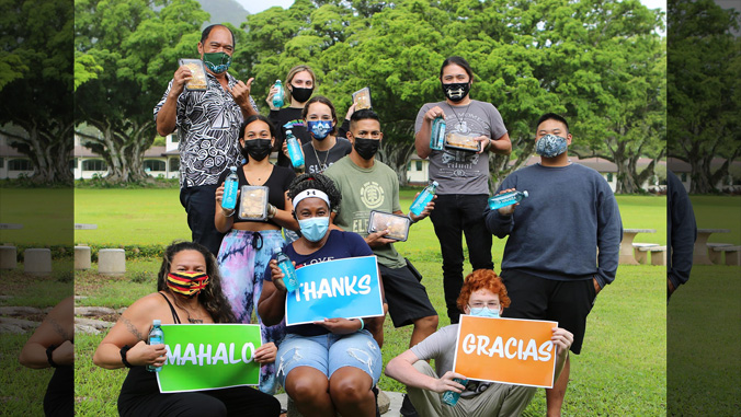 Students in masks with water bottles and thank you signs