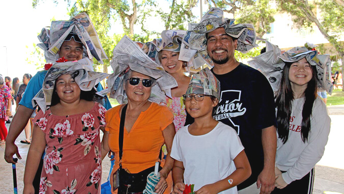group of people wearing newspaper hats
