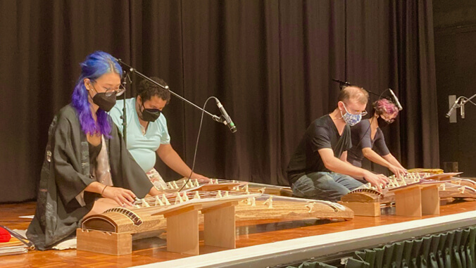 Students on stage playing koto