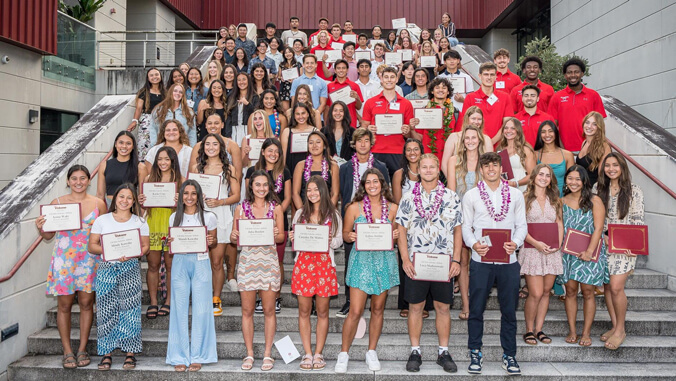 A group of students holding awards