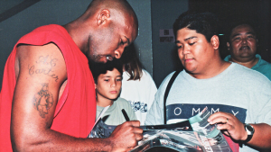 person in a red shirt signing autographs