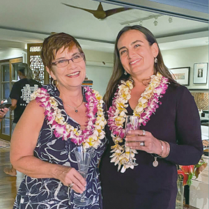 Two women wearing lei and smiling