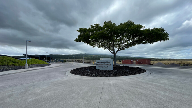 Road at Hawaii Community College, campus sign and tree on a cloudy day