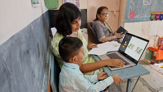 person helping a child work on a computer