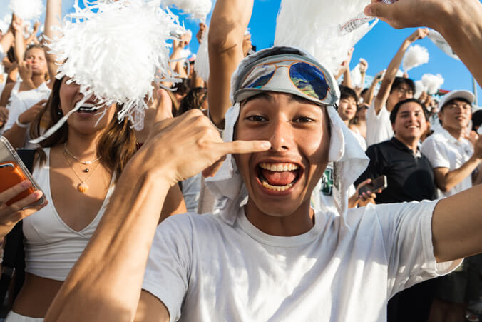 Excited U H Football fan flashing shaka