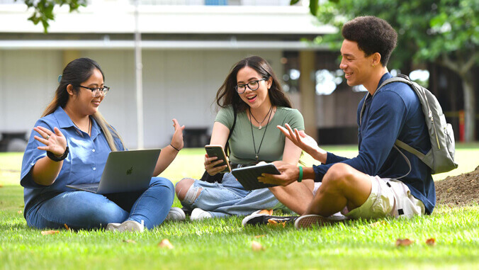 Students sitting on a lawn. 