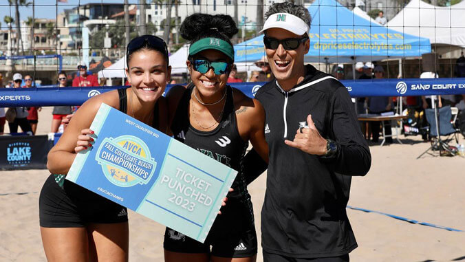 Women's beach volleyball players with coach. 