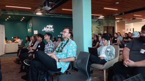 people sitting in chairs looking at a screen