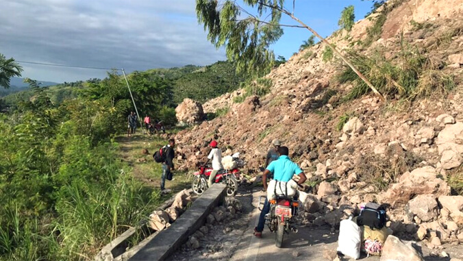 man on a motorcycle blocked by a landslide