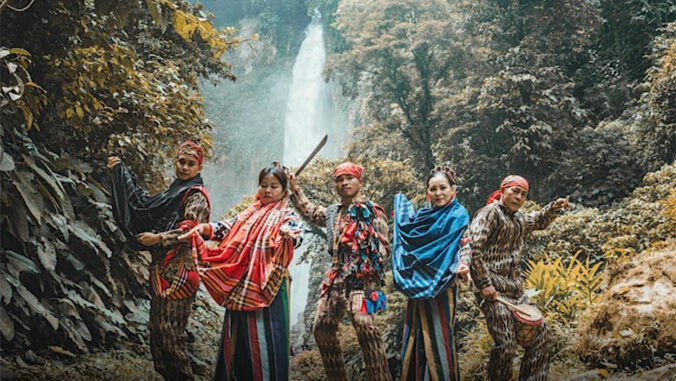 Helobung dancers posing in front of a waterfall