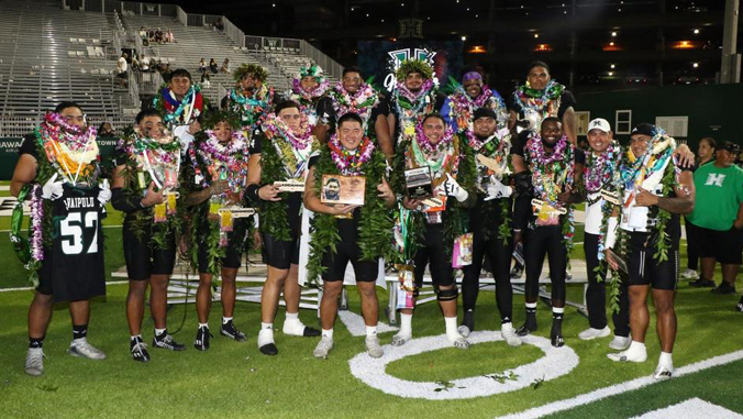 people with jerseys in lei smiling