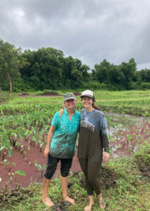 two people standing in front of a taro patch