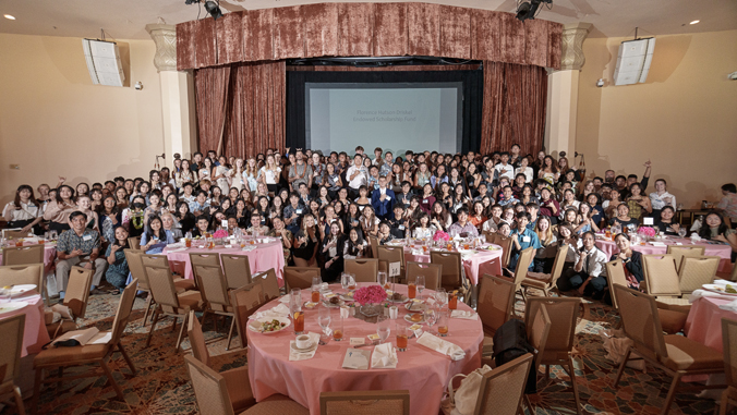 people standing and sitting in a ballroom