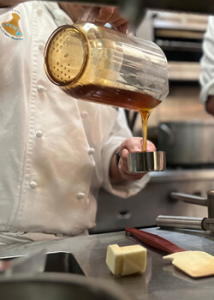 Student pouring honey into a cup