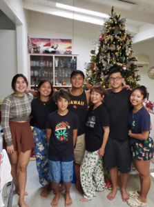 Family standing in front of a Christmas tree